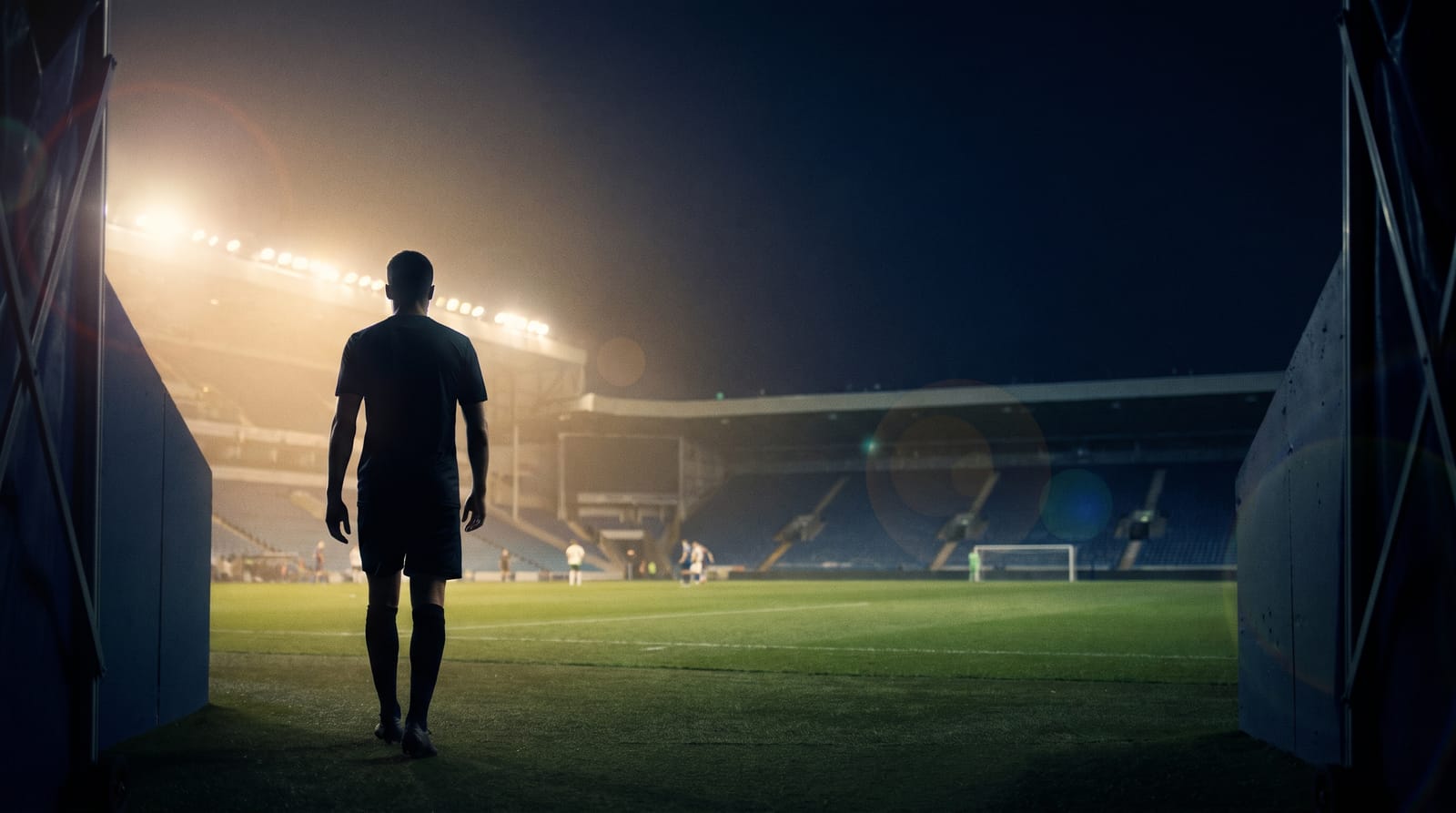 A young football player looking toward the goal at sunrise